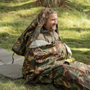 Man sitting outdoors wrapped in original Dutch military DPM camouflage Goretex bivy sack bag