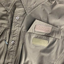 Close-up of TEXAR long-sleeve military shirt showing buttons, collar, and dual patch pockets in durable fabric.