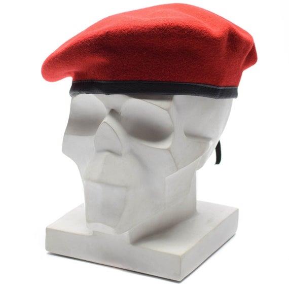 Echte Baskenmütze aus roter Wolle der Bundeswehr, dargestellt auf einem weißen, modernen Skulpturenkopfmodell mit schwarzem Besatzband.