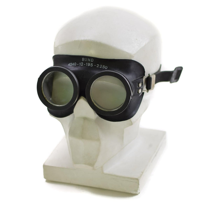 Black genuine German army protection goggles with adjustable strap displayed on white mannequin head