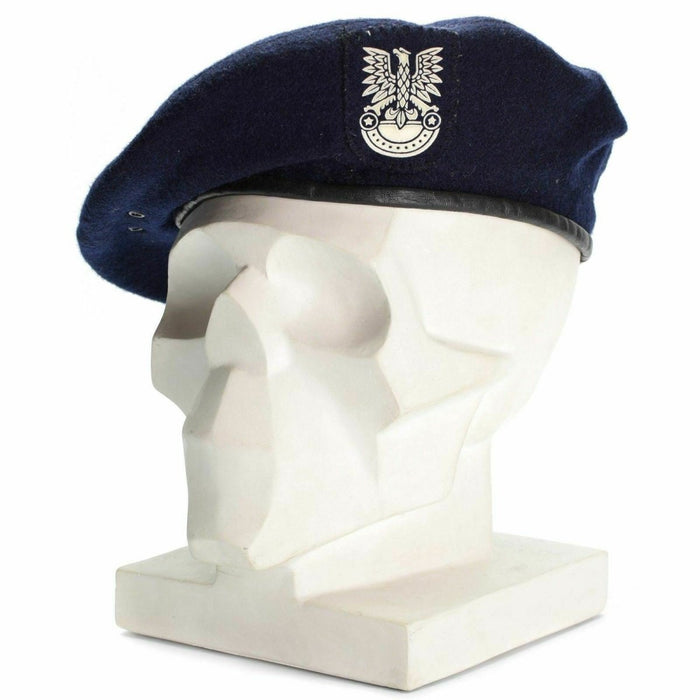 Echtes polnisches, militärisch blaues Barett mit Emblem auf weißem Kopf einer Schaufensterpuppe, das Ehre und Dienst symbolisiert