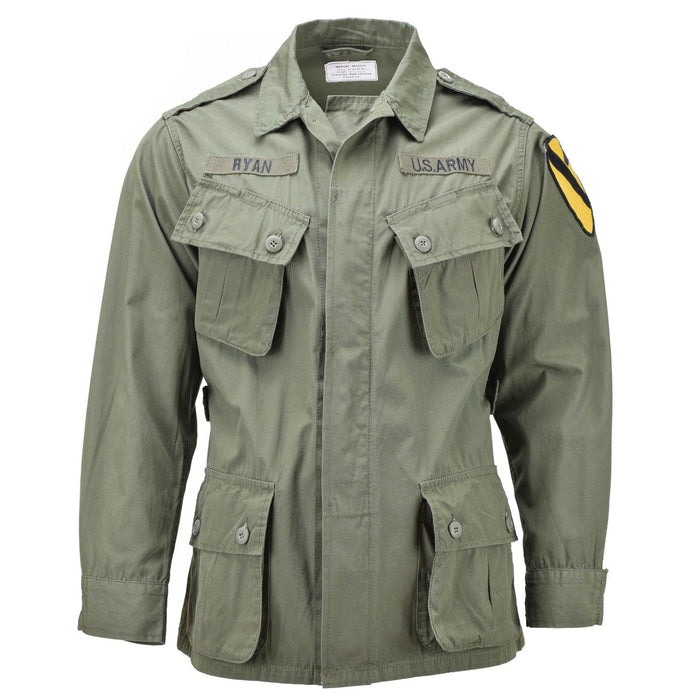 Mil-Tec M64-Dschungeljacke im Vietnam-Stil der US-Armee in Olivgrün mit mehreren Taschen und Militäraufnähern.