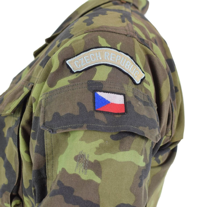 Close-up of Czech Republic military field jacket showing leaf camo pattern and national flag patch on sleeve pocket