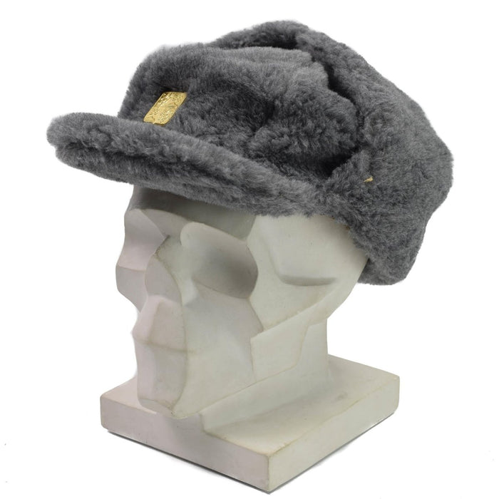 Graue tschechische Militär-Wintermütze aus Kunstpelz mit Ohrenklappen und goldenen Insignien auf einem Schaufensterpuppenkopf