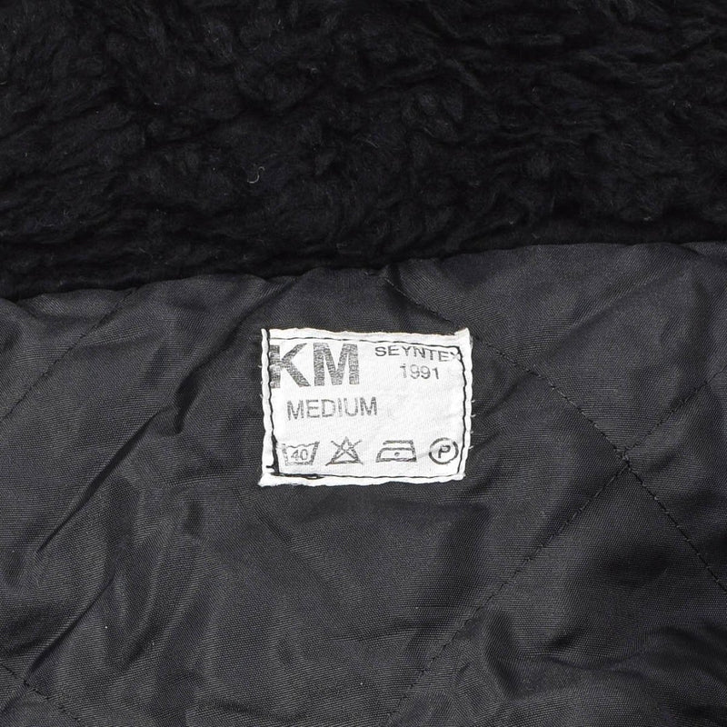 Label inside black faux fur hooded Dutch military winter coverall showing size medium and care instructions