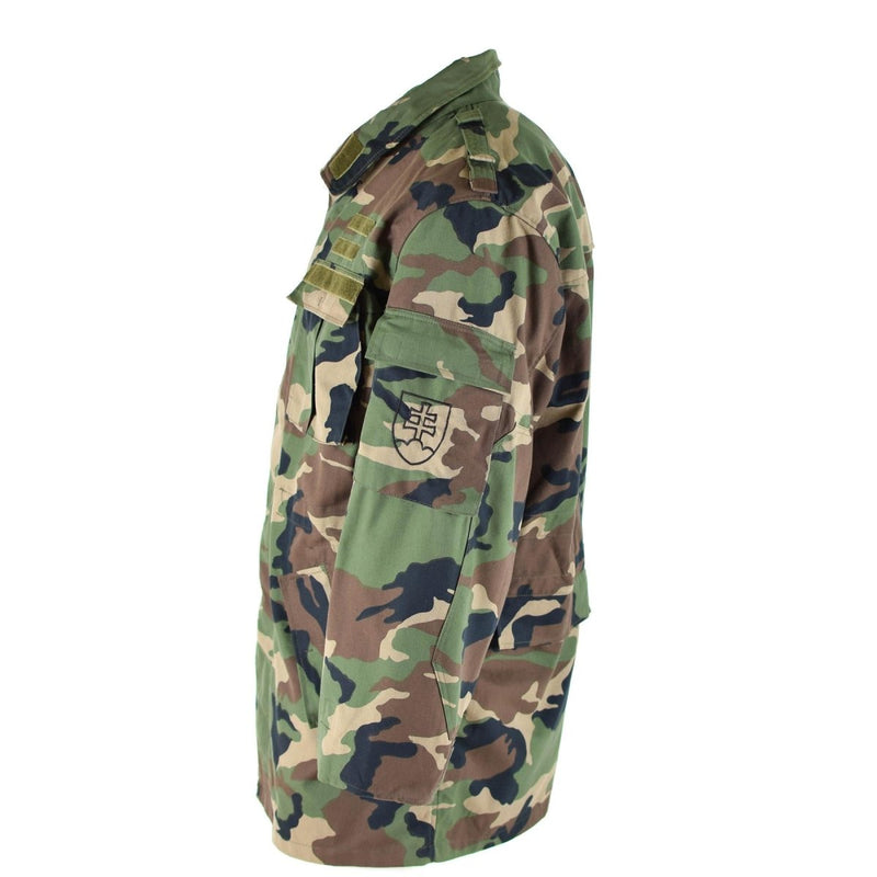 Original vintage Slovakian army field jacket M97 camo military combat parka with chest and arm pockets shown from side view.