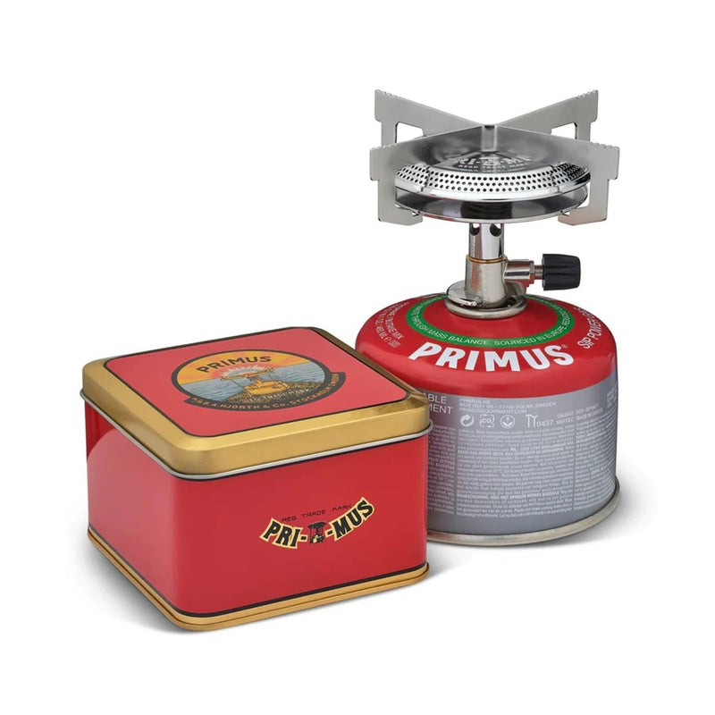 Primus ClassicTrail Stove 130 camping burner with wide flame and red fuel canister next to a red Primus storage tin