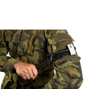Person wearing camouflage uniform applying a black tactical tourniquet with a metal buckle on their arm