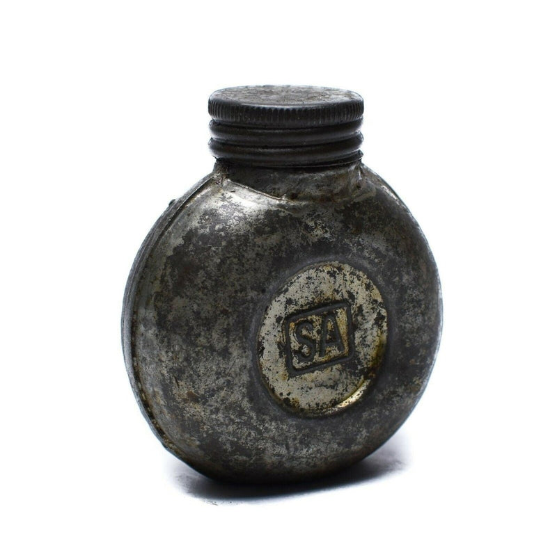 Vintage metal ink bottle with 'SA' logo on a white background